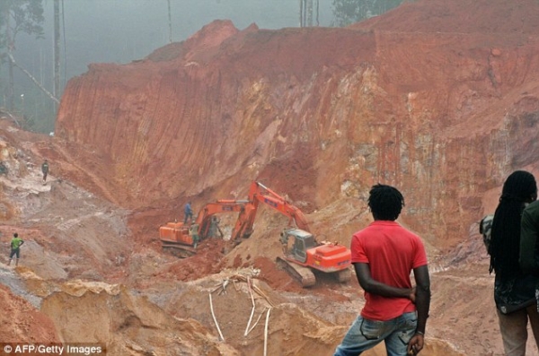 Tragic: People look on as excavators search for the bodies of seven men killed after Saturday&#039;s landslide at a gold mine in eastern Suriname 